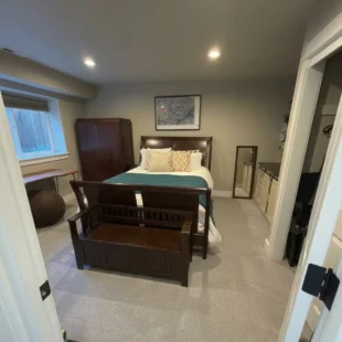 bedroom-carpet-installation-portland-or Newly installed plush grey wall-to-wall carpet in a modern bedroom suite with dark wood furniture in Portland, Oregon
